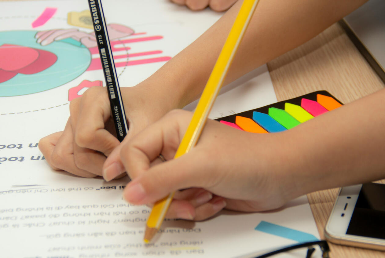 hands coloring a workbook